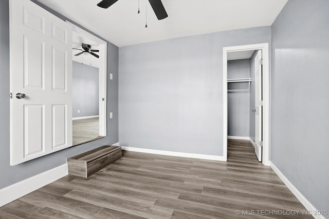 unfurnished bedroom featuring ceiling fan, a closet, and hardwood / wood-style floors