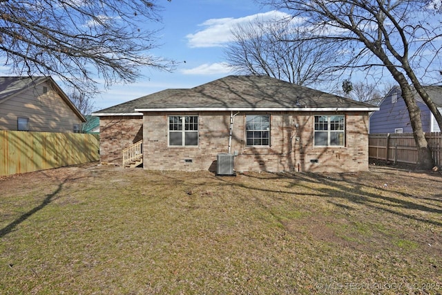 back of house with central AC unit and a lawn