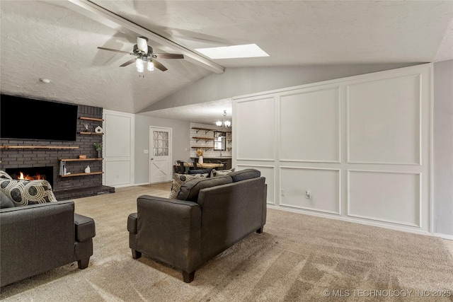 carpeted living room with ceiling fan with notable chandelier, a fireplace, lofted ceiling with beams, and a textured ceiling