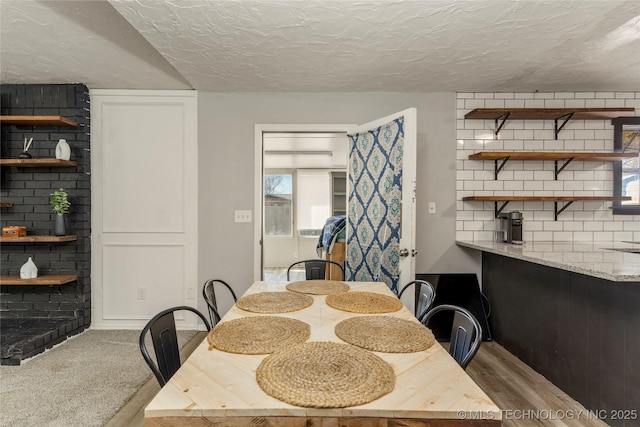 carpeted dining room featuring a textured ceiling