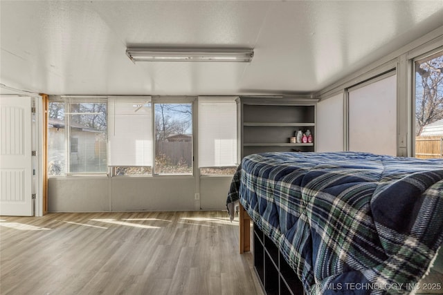 bedroom with hardwood / wood-style floors and a textured ceiling