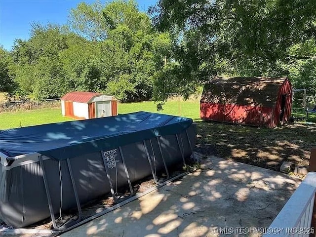 view of swimming pool with a yard and a storage unit