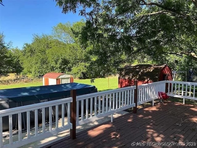 deck featuring a lawn and a shed