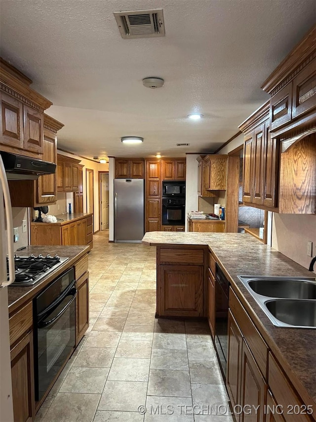 kitchen with sink, a textured ceiling, and black appliances