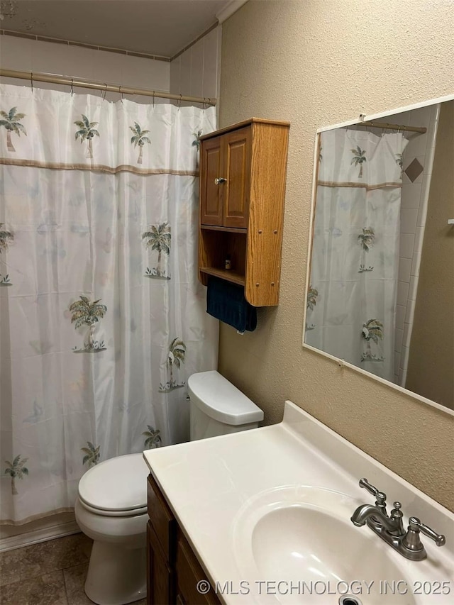 bathroom with toilet, vanity, and walk in shower