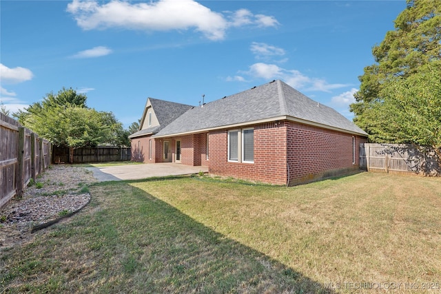 rear view of house with a lawn and a patio area