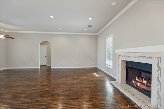 unfurnished living room with ceiling fan, dark wood-type flooring, a high end fireplace, and ornamental molding