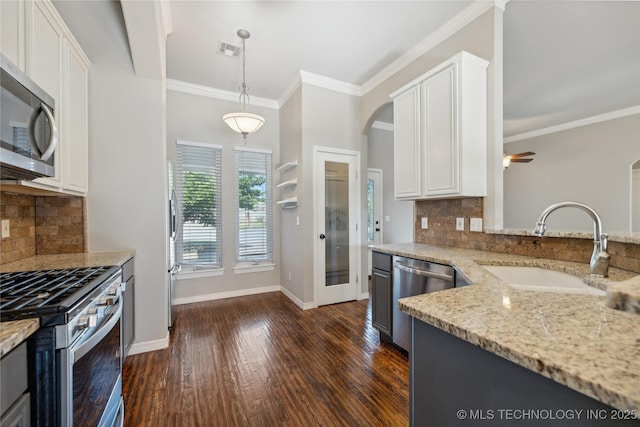 kitchen featuring decorative light fixtures, sink, white cabinets, and stainless steel appliances