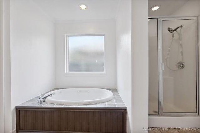 bathroom featuring ornamental molding and separate shower and tub