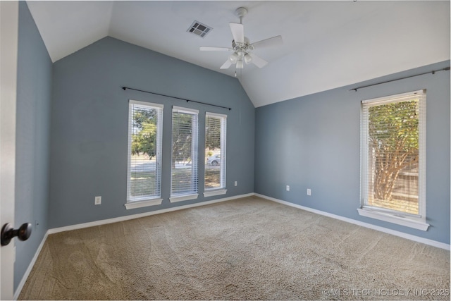 empty room featuring a wealth of natural light, carpet, and lofted ceiling