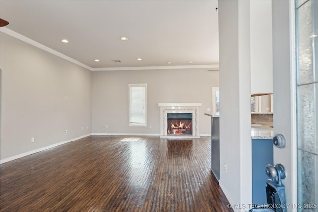 unfurnished living room featuring dark hardwood / wood-style floors, ornamental molding, and a fireplace