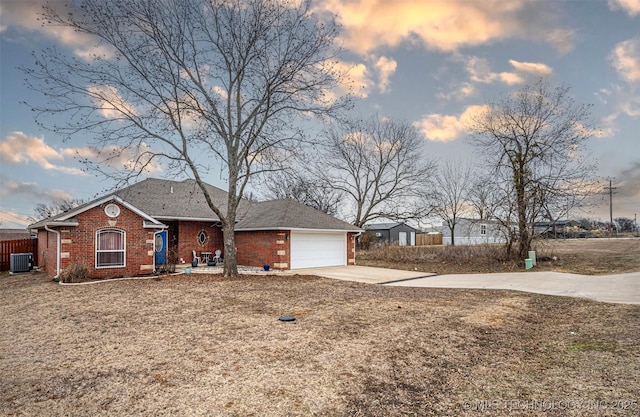 view of front of property with a garage, a yard, and central AC