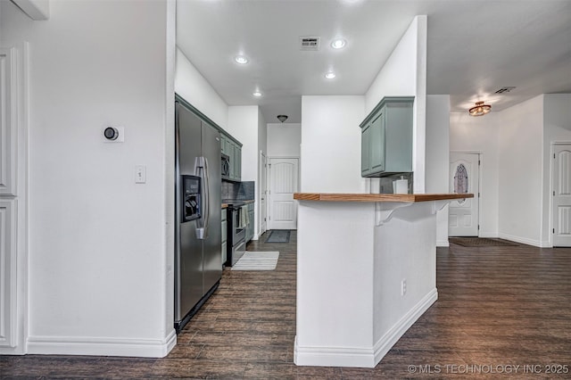 kitchen featuring kitchen peninsula, dark hardwood / wood-style floors, a breakfast bar, and stainless steel appliances