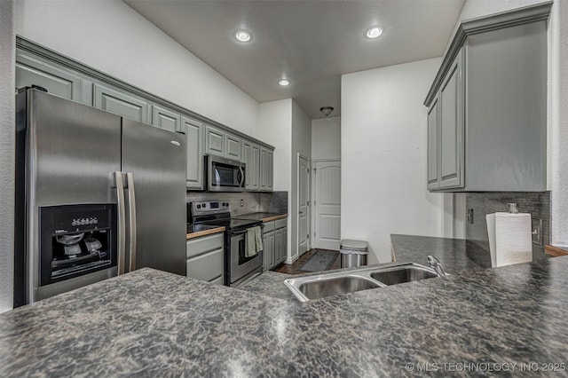 kitchen with sink, decorative backsplash, kitchen peninsula, and stainless steel appliances