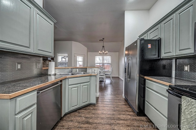 kitchen with sink, appliances with stainless steel finishes, gray cabinetry, and vaulted ceiling