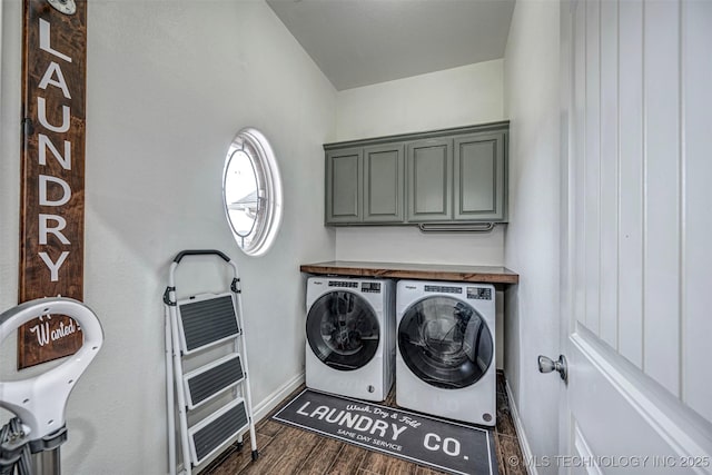 laundry room featuring cabinets, dark wood-type flooring, and washing machine and clothes dryer