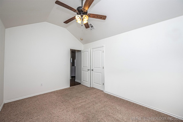 unfurnished bedroom with a closet, ceiling fan, carpet flooring, and vaulted ceiling