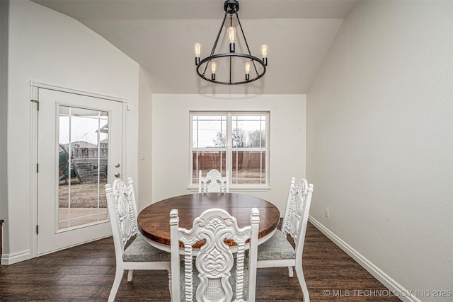 dining area featuring a chandelier, dark hardwood / wood-style floors, and vaulted ceiling