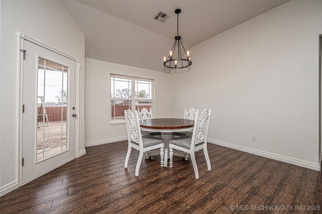 unfurnished dining area featuring a notable chandelier, vaulted ceiling, and dark hardwood / wood-style floors