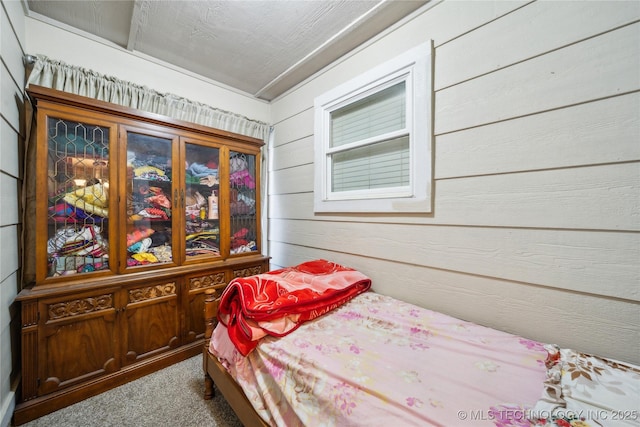 bedroom with carpet and wooden walls