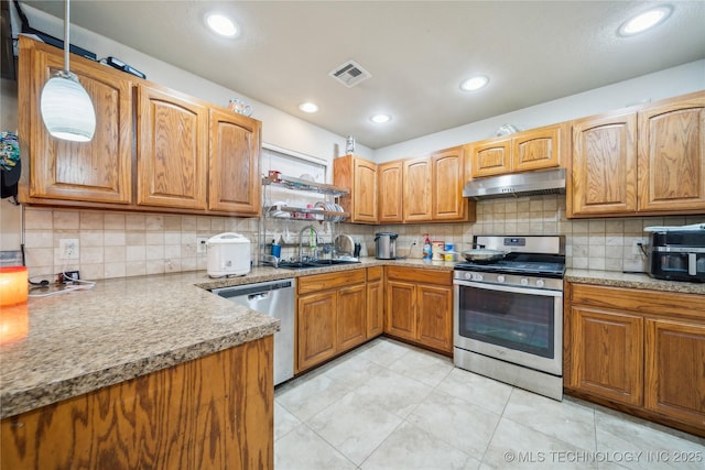 kitchen with stainless steel appliances, brown cabinetry, a sink, and under cabinet range hood