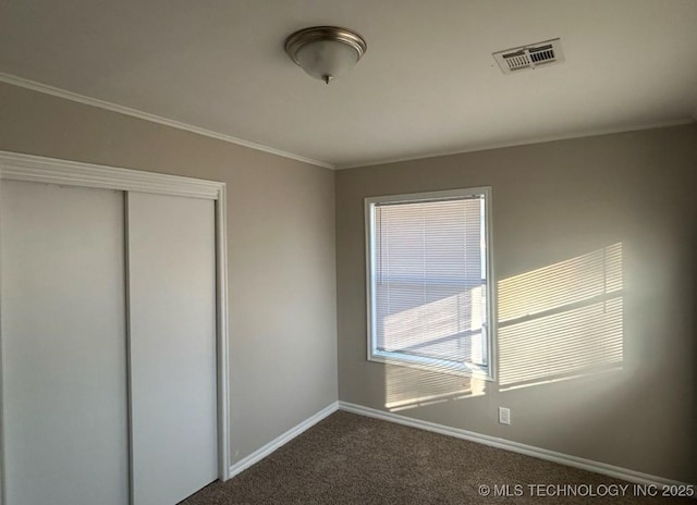 unfurnished bedroom with carpet floors, a closet, and crown molding