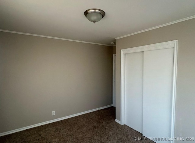 unfurnished bedroom featuring a closet, ornamental molding, and dark carpet