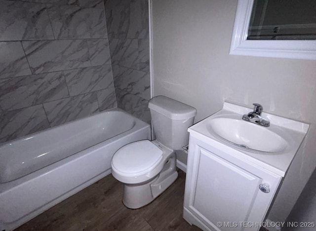 full bathroom with toilet, tiled shower / bath combo, hardwood / wood-style flooring, and vanity