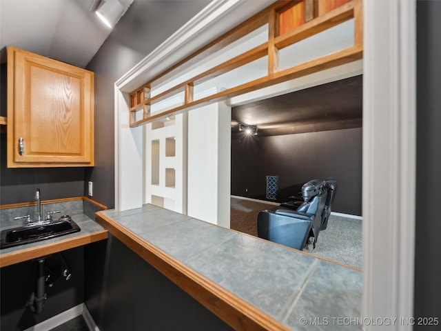 kitchen with sink, tile countertops, and carpet flooring