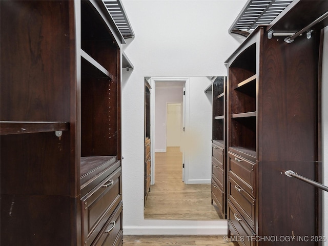 spacious closet with light hardwood / wood-style flooring