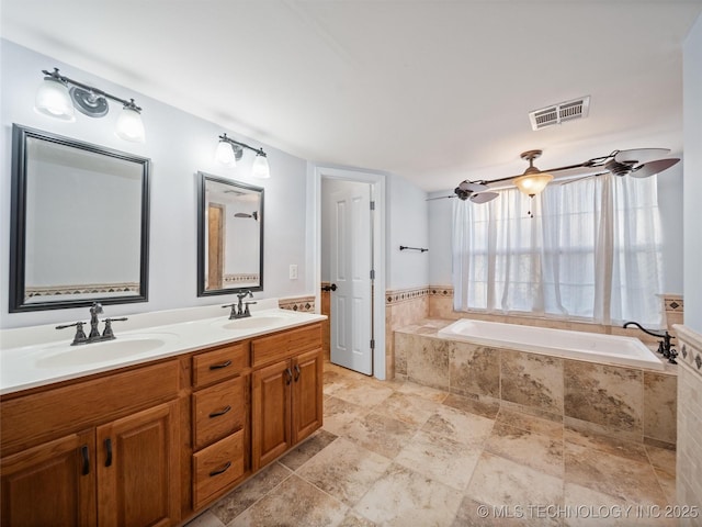 bathroom featuring tiled bath and vanity