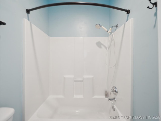 bathroom featuring toilet and shower / tub combination