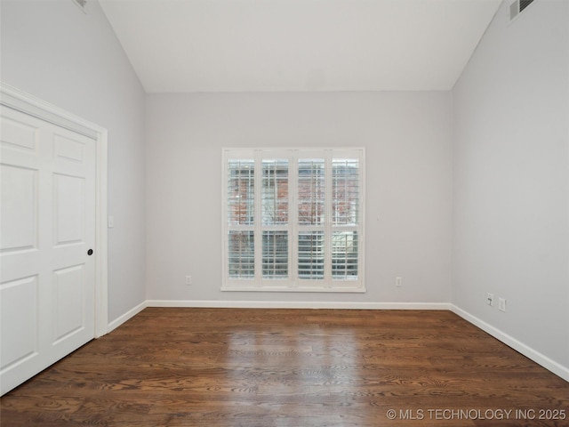 unfurnished room with dark wood-type flooring and lofted ceiling