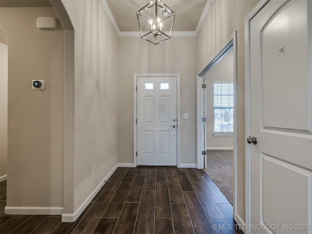 foyer entrance with an inviting chandelier and crown molding