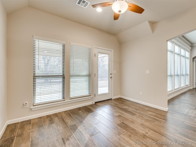 spare room featuring vaulted ceiling, plenty of natural light, and wood-type flooring