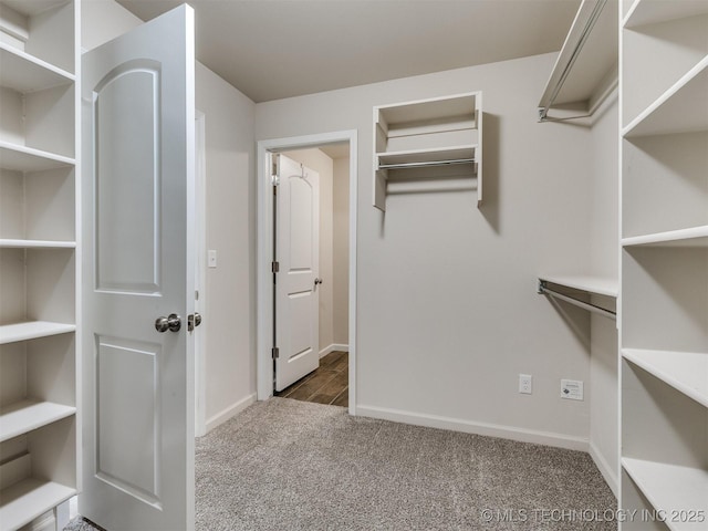 walk in closet featuring dark colored carpet