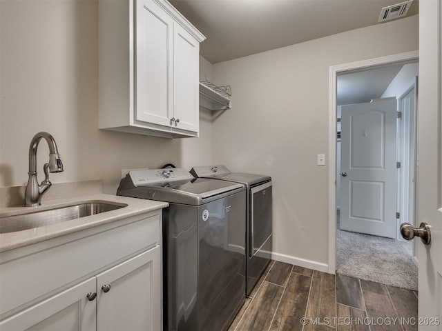 clothes washing area with cabinets, separate washer and dryer, and sink