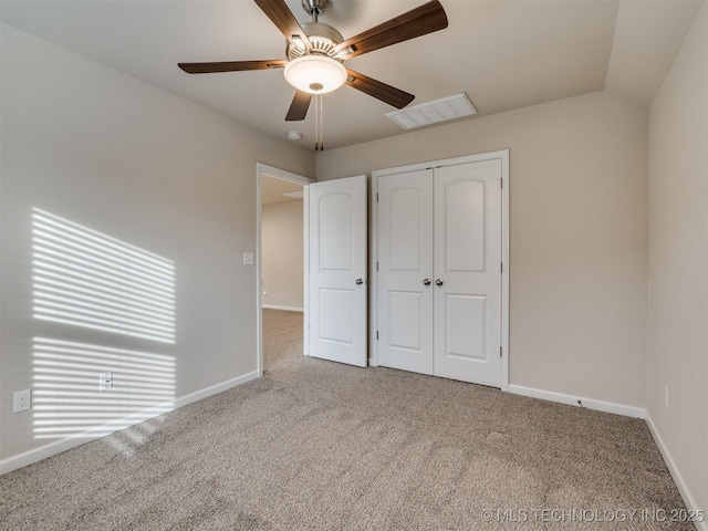 unfurnished bedroom featuring vaulted ceiling, ceiling fan, carpet flooring, and a closet