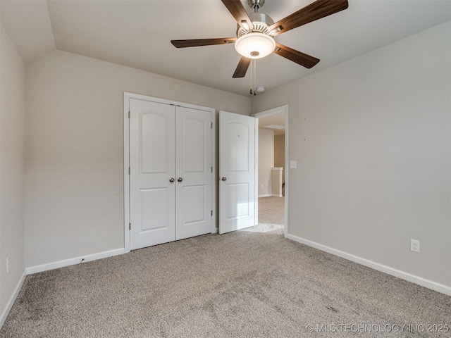 unfurnished bedroom featuring ceiling fan, a closet, vaulted ceiling, and carpet floors