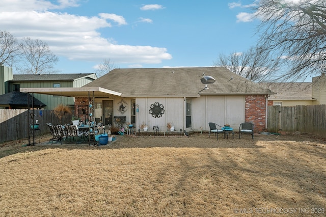 rear view of property featuring a yard and a patio area