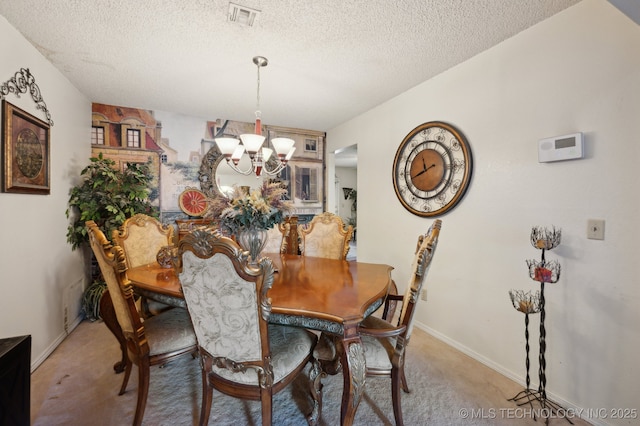 dining room with carpet floors, a textured ceiling, and a notable chandelier