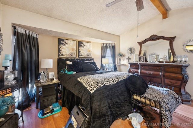 bedroom with hardwood / wood-style flooring, ceiling fan, beam ceiling, and a textured ceiling