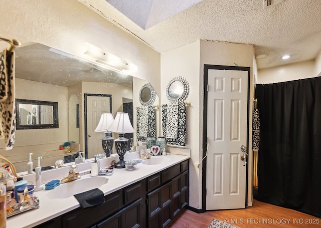 bathroom featuring vanity, hardwood / wood-style flooring, and a textured ceiling