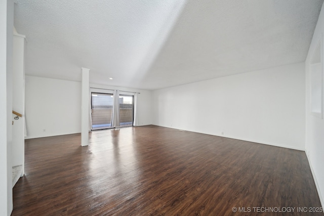 spare room with dark wood-type flooring and a textured ceiling