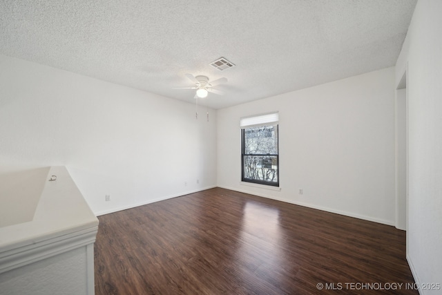 empty room with dark wood-type flooring, a textured ceiling, and ceiling fan