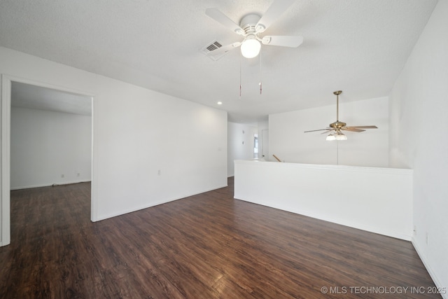 empty room featuring dark wood-type flooring, a textured ceiling, and ceiling fan