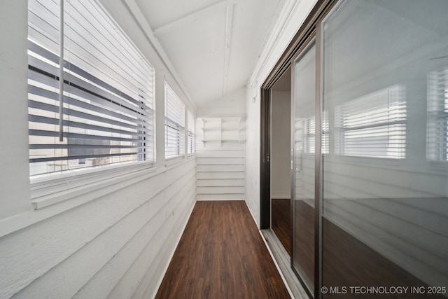 corridor featuring vaulted ceiling and dark wood-type flooring