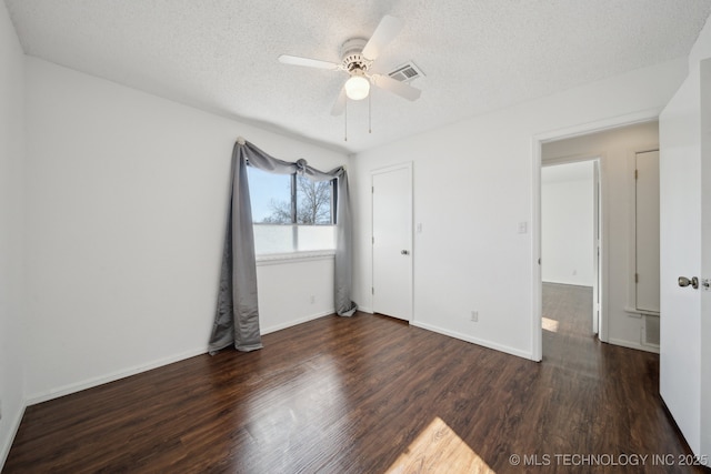 unfurnished room featuring ceiling fan, a textured ceiling, and dark hardwood / wood-style floors