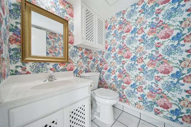 bathroom featuring toilet, vanity, and tile patterned flooring