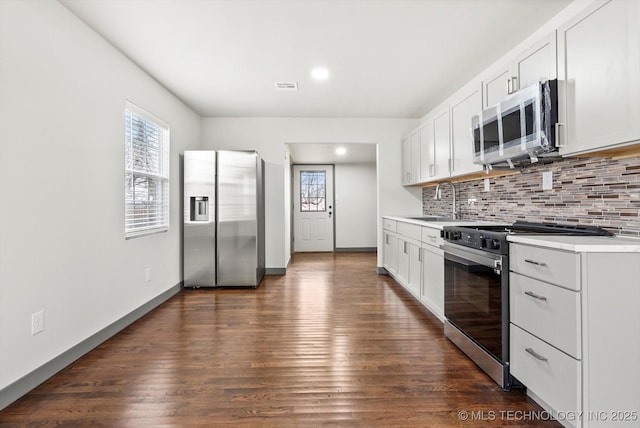 kitchen with tasteful backsplash, sink, appliances with stainless steel finishes, dark wood-type flooring, and white cabinets